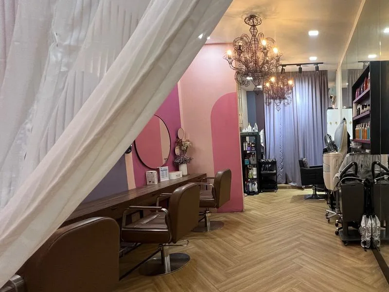 Inside Dashing Diva Plaza Damas: styling chairs under chandeliers, with a curtained treatment area at the back