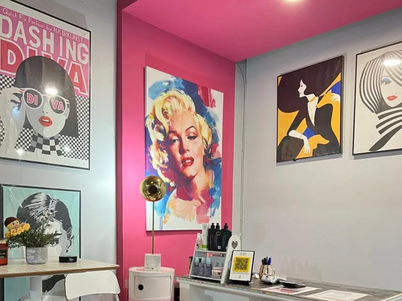 Pop-art posters on pink and white walls at the Dashing Diva Shah Alam reception corner